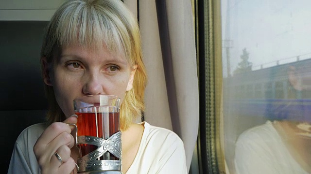 一个女人正在火车上喝茶。旅游与安慰