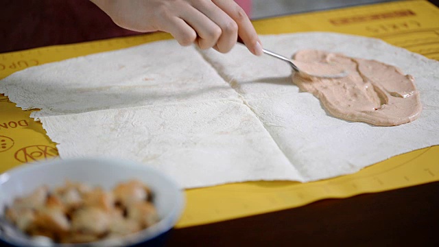 把酱汁放在皮塔饼上。做饭吃沙瓦玛