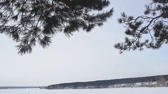 背着背包在山里徒步旅行的女孩。天气寒冷，山上有雪。冬季徒步旅行。一个背着双肩包的女人在欣赏冬季群山的景色。生活方式