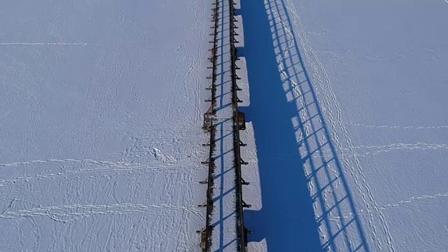 无人机飞越雪湖木桥