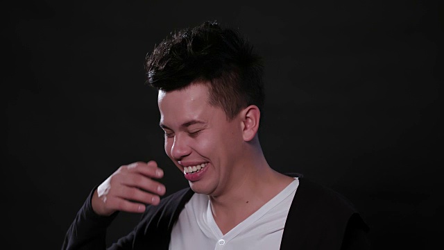 在黑色背景下微笑的男人的脸