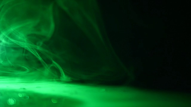 神奇的绿色肥皂泡把戏在黑色的背景黑色的桌子上