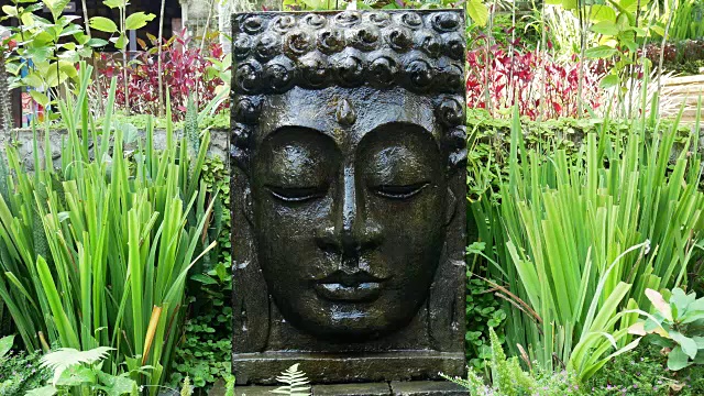 在巴厘岛乌布的热带花园中，佛陀与落水。