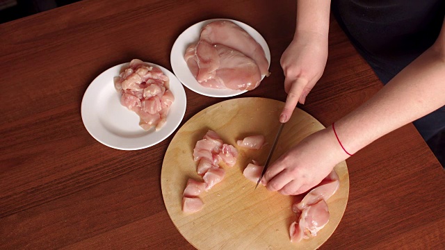 女手厨师切生鸡胸肉。