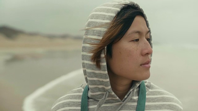 亚洲女人独自走在沙滩上沉思的肖像