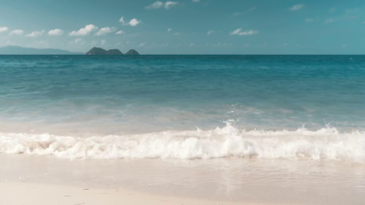 海滩上的波浪，地平线上的岛屿