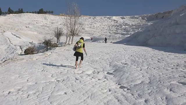 女人的腿在流动的水在Pamukkale