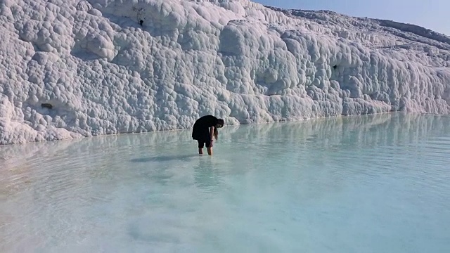 女人的腿在流动的水在Pamukkale