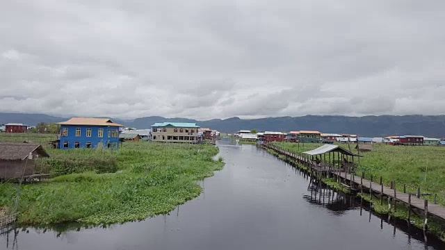 无人机在东南亚的一个湖泊上空拍摄，鸟瞰湖面上令人惊叹的木桥，漂浮的花园和缅甸茵莱湖上的村庄