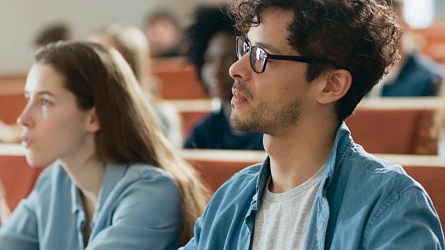 西班牙裔学生在教室里认真听讲座。年轻人在大学学习。