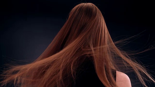 美丽的深色金发女人甩着长发