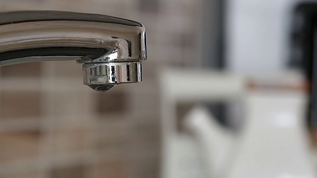 水从水龙头里慢慢滴下来