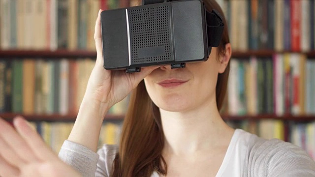 詳情圖-年輕女子在家里使用VR,360眼鏡?？吹搅钊伺d奮的東西，用手做手勢