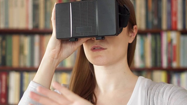 詳情圖-年輕女子在家里使用VR,360眼鏡?？吹搅钊伺d奮的東西，用手做手勢