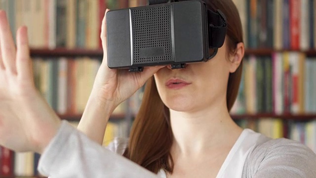 詳情圖-年輕女子在家里使用VR,360眼鏡。看到令人興奮的東西，用手做手勢