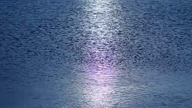 水面在太阳的照耀下闪闪发光，有一条太阳的路径在水面上