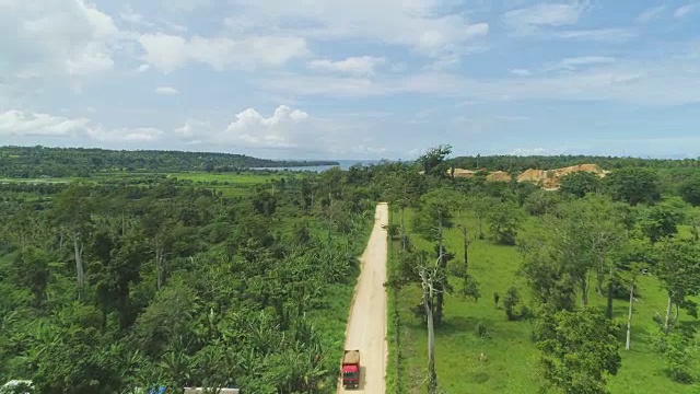 航拍:飞过砾石路，前往热带森林附近繁忙的采石场。