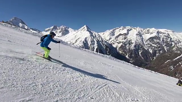 在阳光明媚的冬日，高山滑雪者在滑雪场滑雪