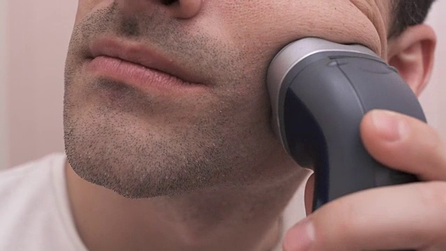 刮胡子认真的男人，剃须刀电动剃须刀