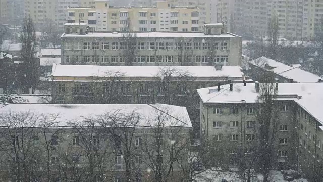 城市里降雪的慢动作。冬天好背景。冬天