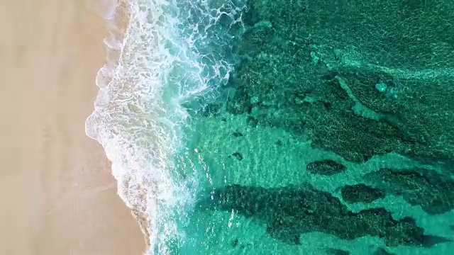 鳥瞰圖海浪撞擊白沙海灘的局部海岸線在夏季海灘日與珊瑚礁
