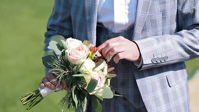 新郎捧着婚礼花束。