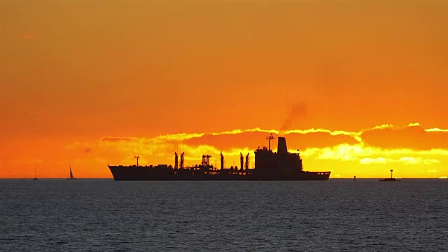 在4k慢镜头的夕阳下，一艘集装箱货轮在海上航行