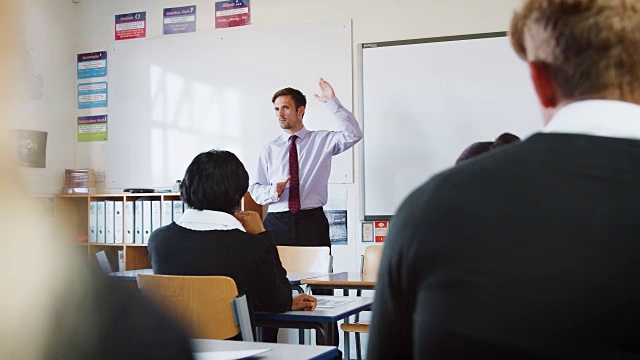 十几岁的学生在教室里听男老师讲课