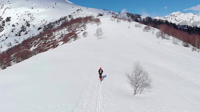 徒步者攀登雪山，滑雪旅游偏僻的雪道独自登山，风景秀丽的雪山背景。