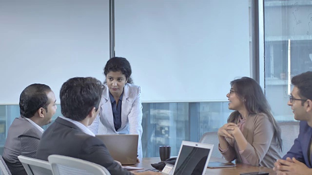 年轻自信的女商人在一次会议上与同事谈论即将到来的财务任务。