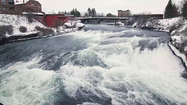 城市景观在冬季雪的寒冷河流急流