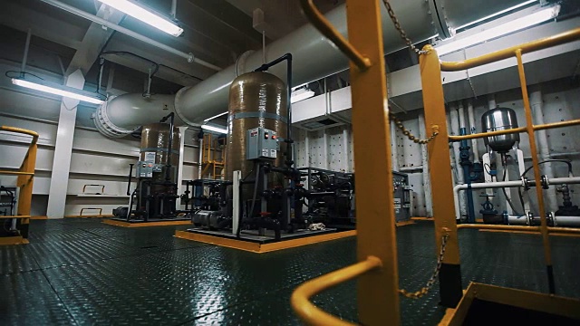 在生产设施内，两个圆柱体金属结构与控制面板