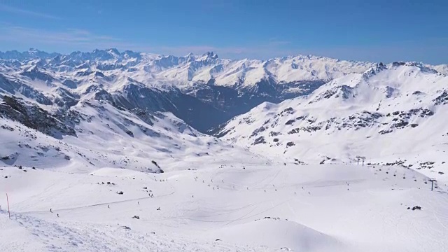 令人叹为观止的雪山全景和滑雪者在斜坡上