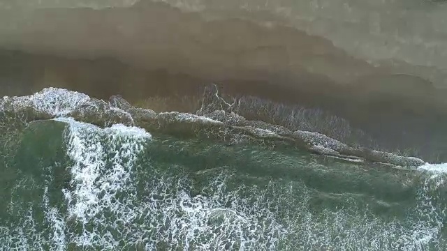 空中从上到下拍摄沙滩上的海浪