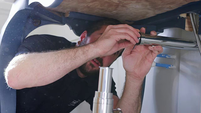 水管工为浴室洗脸盆安装新的污水收集器