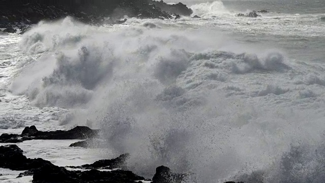 詳情圖-巨浪滾向多巖石的海岸。浪花飛濺在馬刺上。慢動作鏡頭