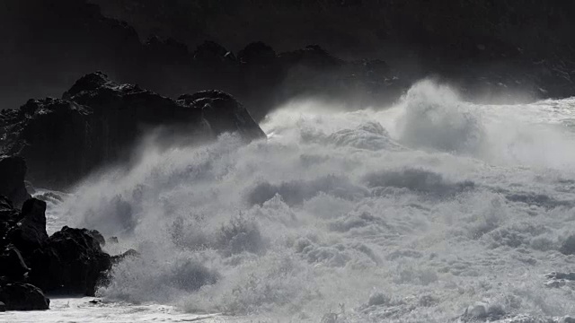 詳情圖-巨浪滾向多巖石的海岸。浪花飛濺在馬刺上。慢動作鏡頭