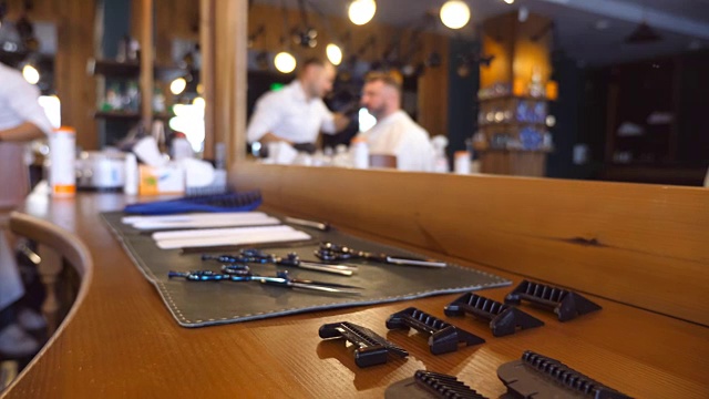 多莉拍摄餐桌上的美发师工具。理发店的配件和工具。弄头发的过程。近距离