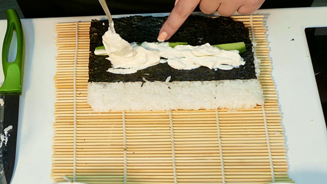 厨师把海苔和米饭翻过来铺上馅料