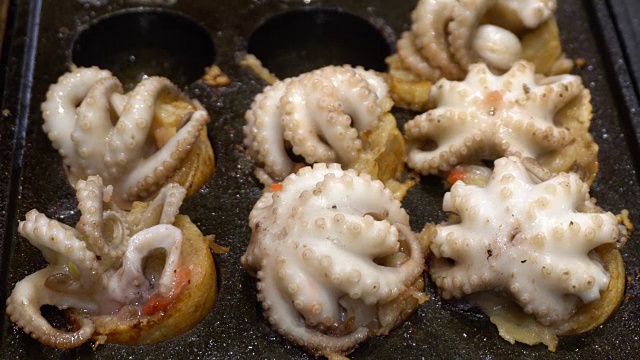 烹饪球形街头小吃饺子与大鱿鱼油炸小吃在日本。这种食物的日本名字叫章鱼烧。4 k UHD