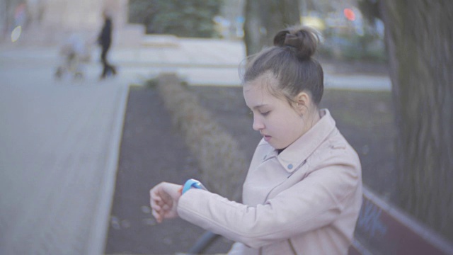一个年轻女孩在户外吃热狗。漂亮少女在公园吃热狗。