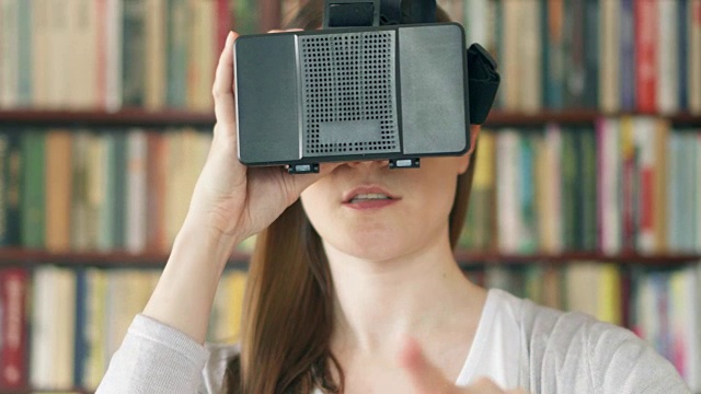 詳情圖-年輕女子在家里使用VR,360眼鏡?？吹搅钊伺d奮的東西，用手做手勢