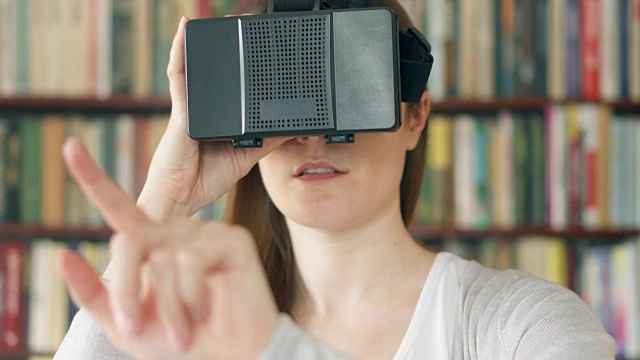 詳情圖-年輕女子在家里使用VR,360眼鏡?？吹搅钊伺d奮的東西，用手做手勢