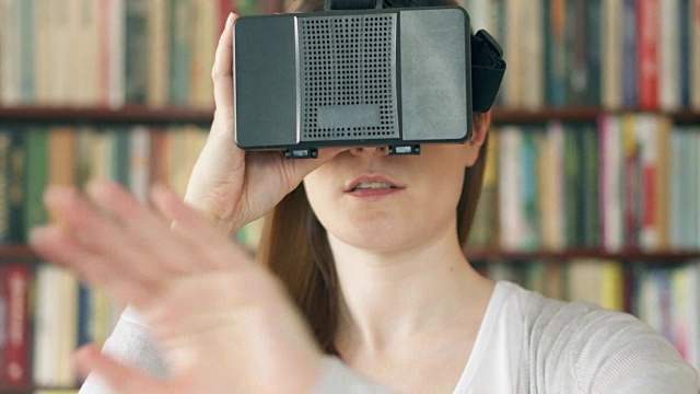 詳情圖-年輕女子在家里使用VR,360眼鏡?？吹搅钊伺d奮的東西，用手做手勢