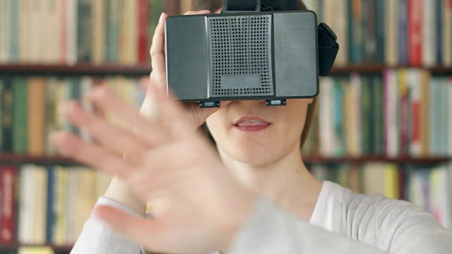 詳情圖-年輕女子在家里使用VR,360眼鏡?？吹搅钊伺d奮的東西，用手做手勢