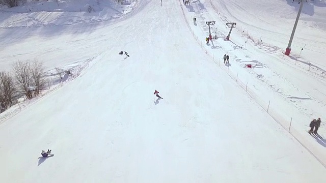 空中拍摄从飞行无人机人滑雪和滑雪场雪坡滑雪板。雪山上的滑雪电梯。冬季滑雪胜地的活动