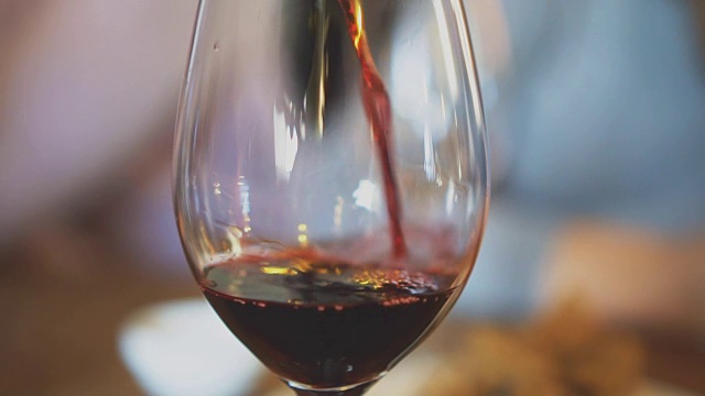 将红酒从瓶中倒入玻璃杯。葡萄酒品尝。