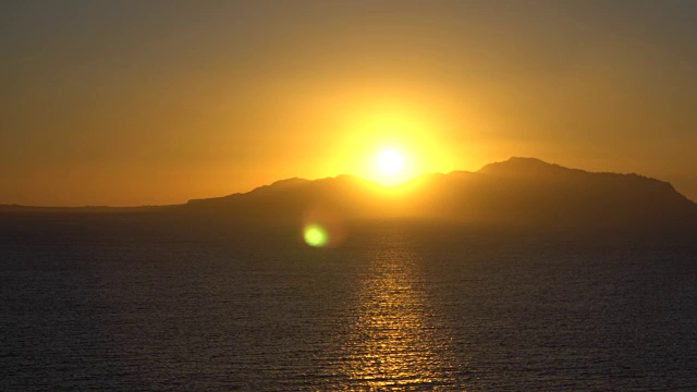 冉冉升起的太阳越过大海和沙漠山脉