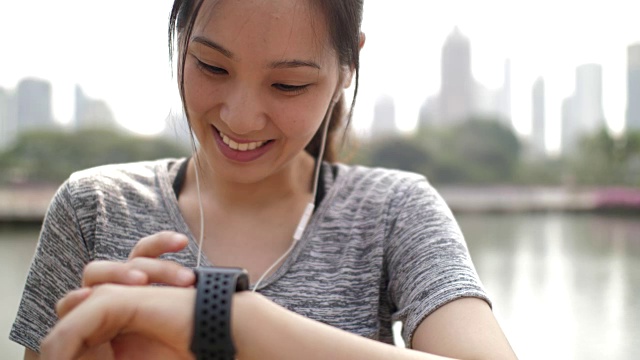 亚洲女人在智能手表上检查脉搏