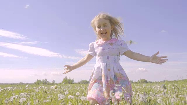 詳情圖-可愛的小女孩在蒲公英色的草地上奔跑。孩子們在戶外歡聲笑語。夏天陽光燦爛的日子。緩慢的運動。
